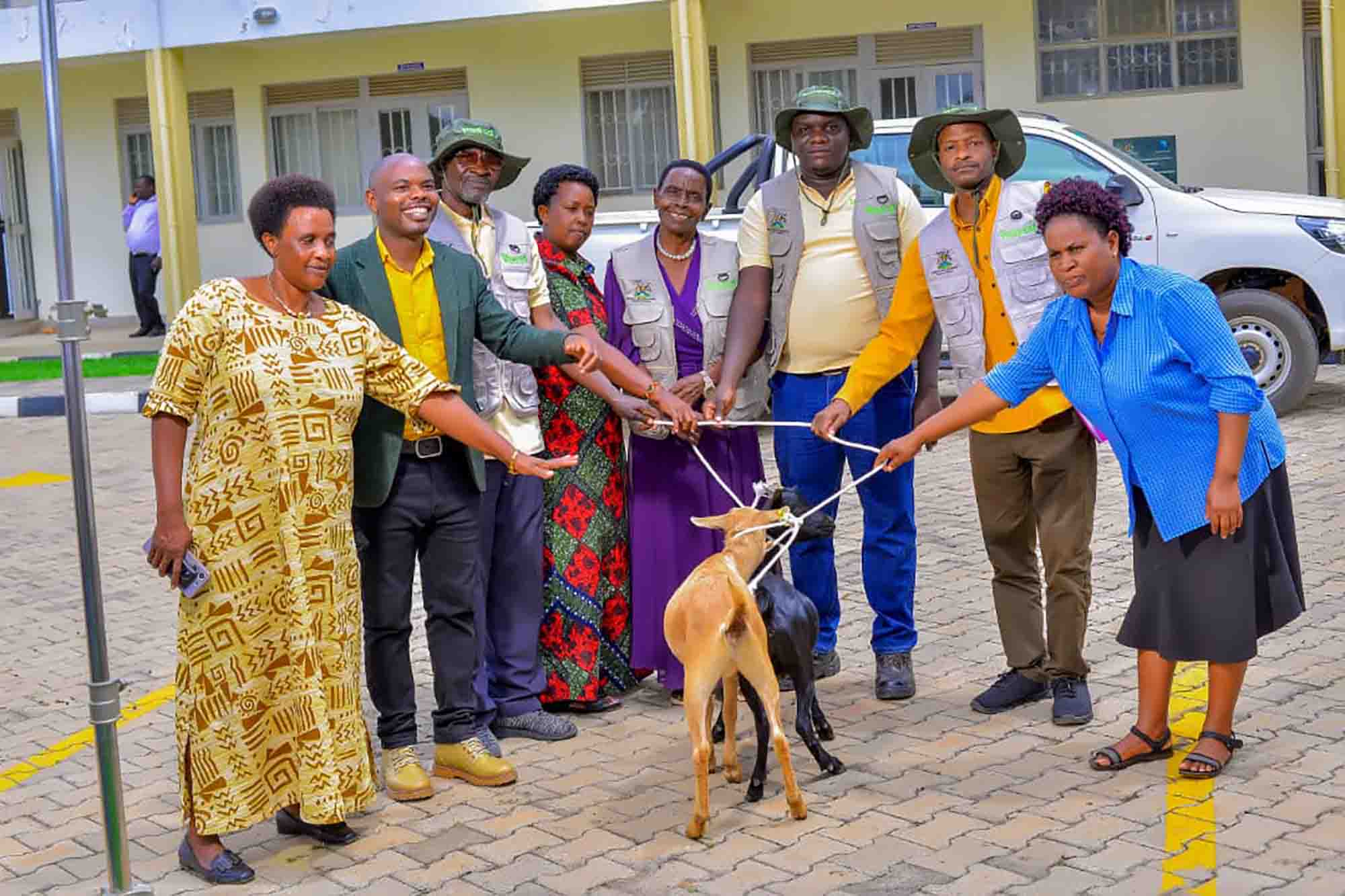Agroup photo of ECOTRUST together with some local government officials handing over 2 improved goats to one of the model farmers awarded